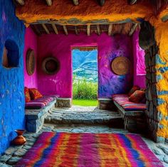 a room with colorful walls and rugs on the floor in front of an open door