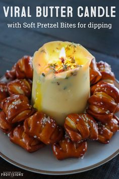 a plate topped with pretzel bites and a small candle on top of it