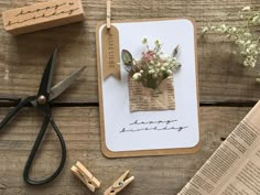 flowers are placed on top of a piece of paper next to scissors and some typewriters