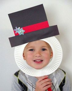 a young boy wearing a paper plate hat