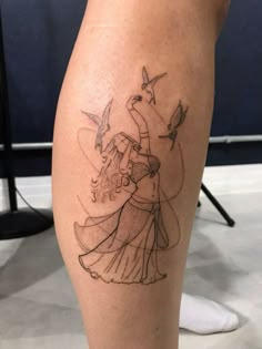 a woman's leg with a tattoo on it that has a drawing of two people dancing