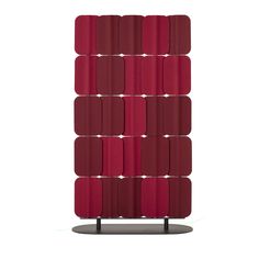 a red wall hanging on the side of a white wall next to a metal stand