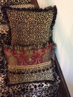 three leopard print pillows stacked on top of each other in front of a white wall