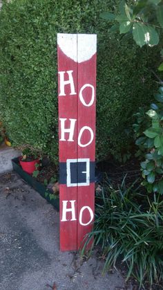 a red and white sign that says ho hoo on it's side in front of some bushes