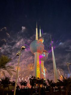 fireworks are lit up in the sky above a building with a tower on it's side