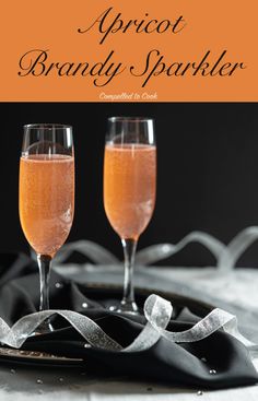 two glasses of spritet brandy sparkler on a black plate with silver ribbon