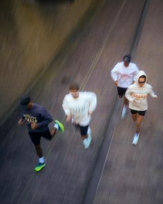 three people are running down the street together