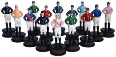 a group of toy figurines of jockeys on black bases with white background