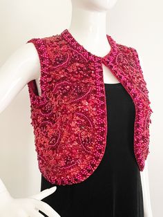 This is a beaded vest from Valentina, Ltd made in Hong Kong.  The beads are sewn to wool.  The lining feels like silk.  The front is thickly encrusted with a combination of sequins, beads and jewels.  There is an additional embellishment of pink pearls in an abstract design and along the edges.  The entire back is fully sequined with the same pearl trim as the front. One hook and eye closure. There is some damage to the lining, a small hole and a stain.  See pic.  This in no way interferes with the wearability of this vest.  Sturdy and ready to wear.  A few loose beads may be present.   Measurements taken with vest laying flat and doubled where appropriate. In order to determine fit we recommend comparing measurements to an item that fits you well. No stretch.  Length 16 inches Underarm to Beaded Vest, 2024 Wishlist, Long Sleeve Evening Gowns, Pink Pearls, Vintage Style Dresses, Vest Outfits, Sequin Beading, Pink Sequin, Pink Pearl