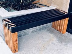 a wooden bench sitting next to a planter