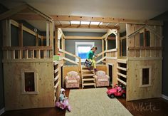 a room with bunk beds and toys on the floor in front of it is a loft bed