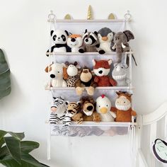 a rack with stuffed animals hanging on it's sides next to a potted plant