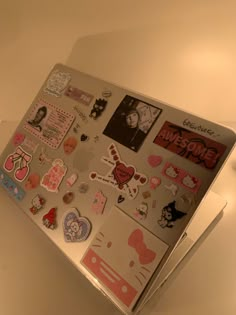 a laptop covered in lots of stickers and magnets on the back of it