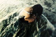 a woman is laying down in the water