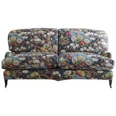 a floral patterned couch with wooden legs