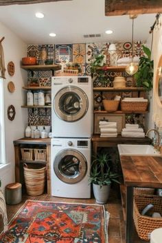 a washer and dryer sitting in a room next to a table with baskets on it