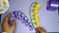 someone is cutting out flowers with scissors on a purple tablecloth that says thank you for watching