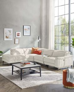 a living room with a sectional couch and coffee table in front of a large window