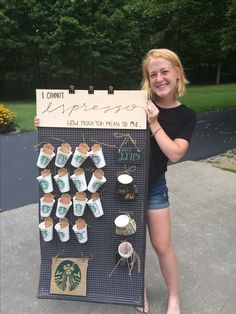 a woman holding up a sign with coffee cups on it