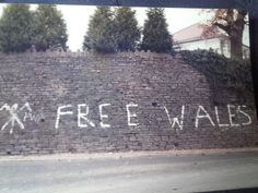 graffiti on the side of a brick wall that says free walies written in white spray paint