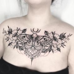 a woman's chest with a butterfly and flowers tattoo design on her left side