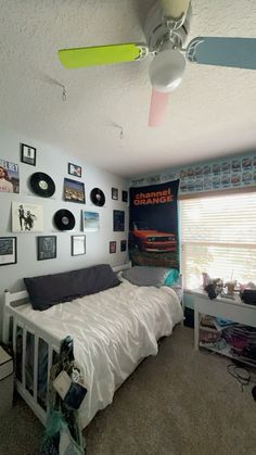 a bed room with a neatly made bed and lots of pictures on the wall above it