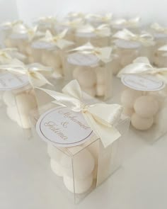 wedding favors are wrapped in white paper and tied with a bow