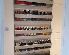 an organized shoe rack in the corner of a room