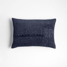 a black and white pillow on a white wall with a dark blue pattern in the middle