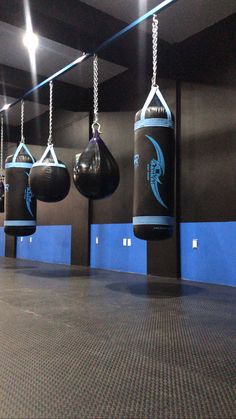 an empty gym with boxing gloves hanging from the ceiling