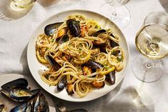 a plate of pasta with mussels and wine