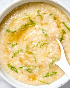 a white bowl filled with oatmeal topped with green leaves