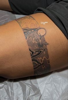 a person with a tattoo on their arm and leg sitting on a sheet of foil