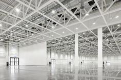 an empty warehouse with white walls and ceilinging is seen in this image from the inside