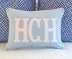 two blue and white pillows with the letter h on them