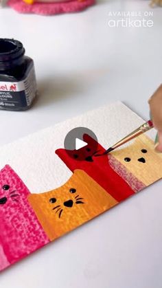 someone is painting an image on paper with paintbrushes and glue to make it look like cats