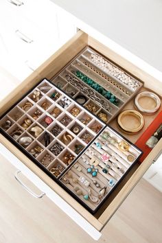 an open drawer with jewelry and bracelets in it