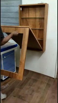 a man standing next to a wooden desk with an open drawer on top of it