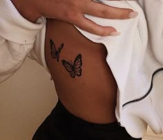 a woman's stomach with two butterflies on her side and the bottom part of her body