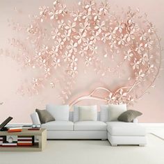 a living room with white furniture and pink wallpaper on the walls, along with a large floral tree mural