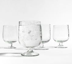 three empty wine glasses sitting on top of each other in front of a white background