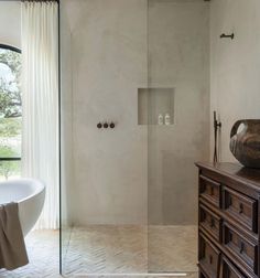 a bath room with a tub a sink and a window