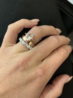 a close up of a person's hand with two rings on their wedding band