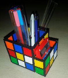 a pen holder made out of legos with pens and pencils in the middle