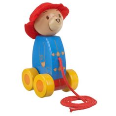 a toy bear with a red hat on it's head is pulling a rope