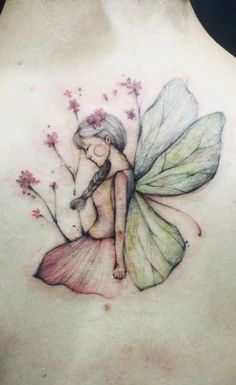 a woman's back with a fairy tattoo on her shoulder and the image of a flower