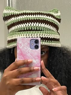 a woman is taking a selfie with her cell phone in front of her hat