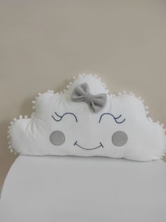 a white pillow with a bow on it's head and eyes drawn on the side