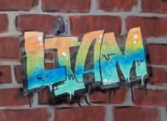 graffiti on the side of a brick wall that says flyin in blue, yellow and green