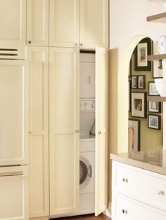 a washer and dryer in a room with pictures on the wall